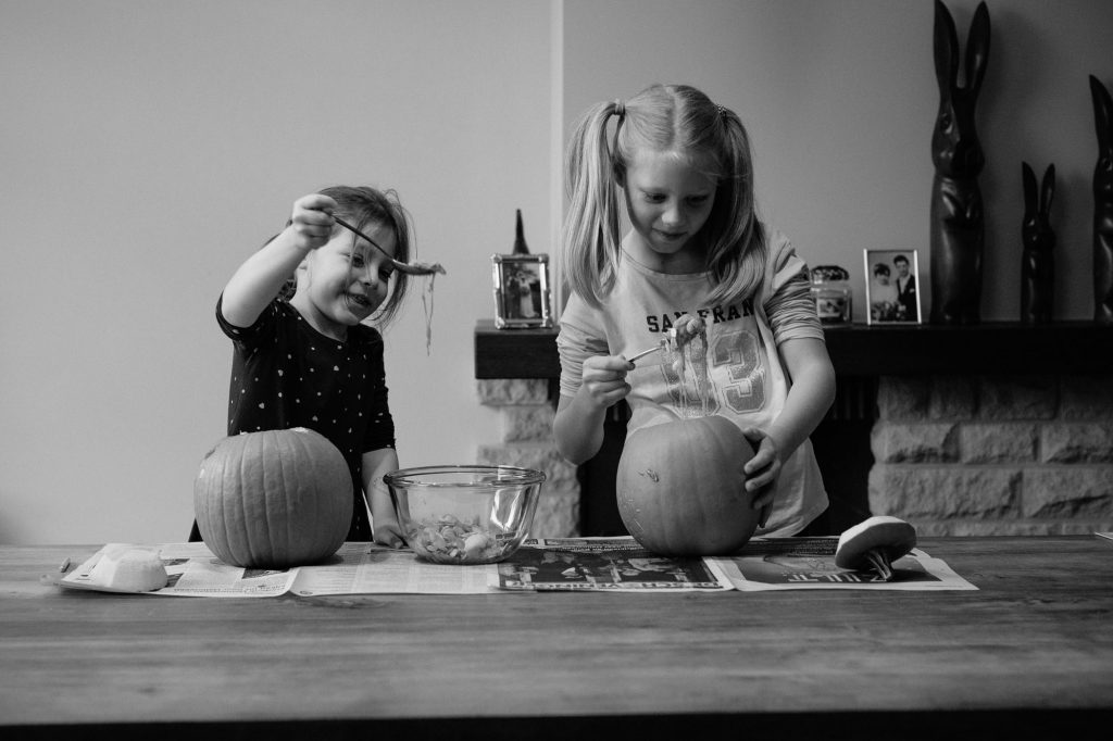 Two sisters carving pumpkins for halloween
