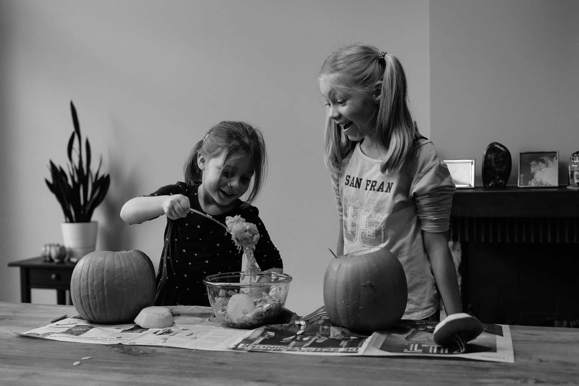 Sisters carving pumpkins for halloween